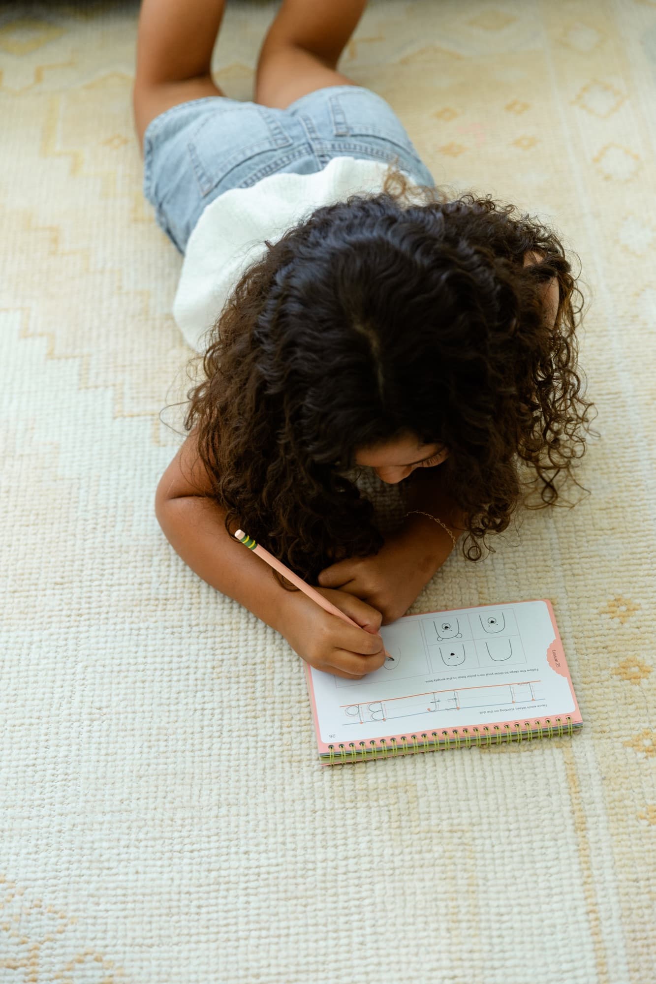 A child practicing letters in the handwriting book