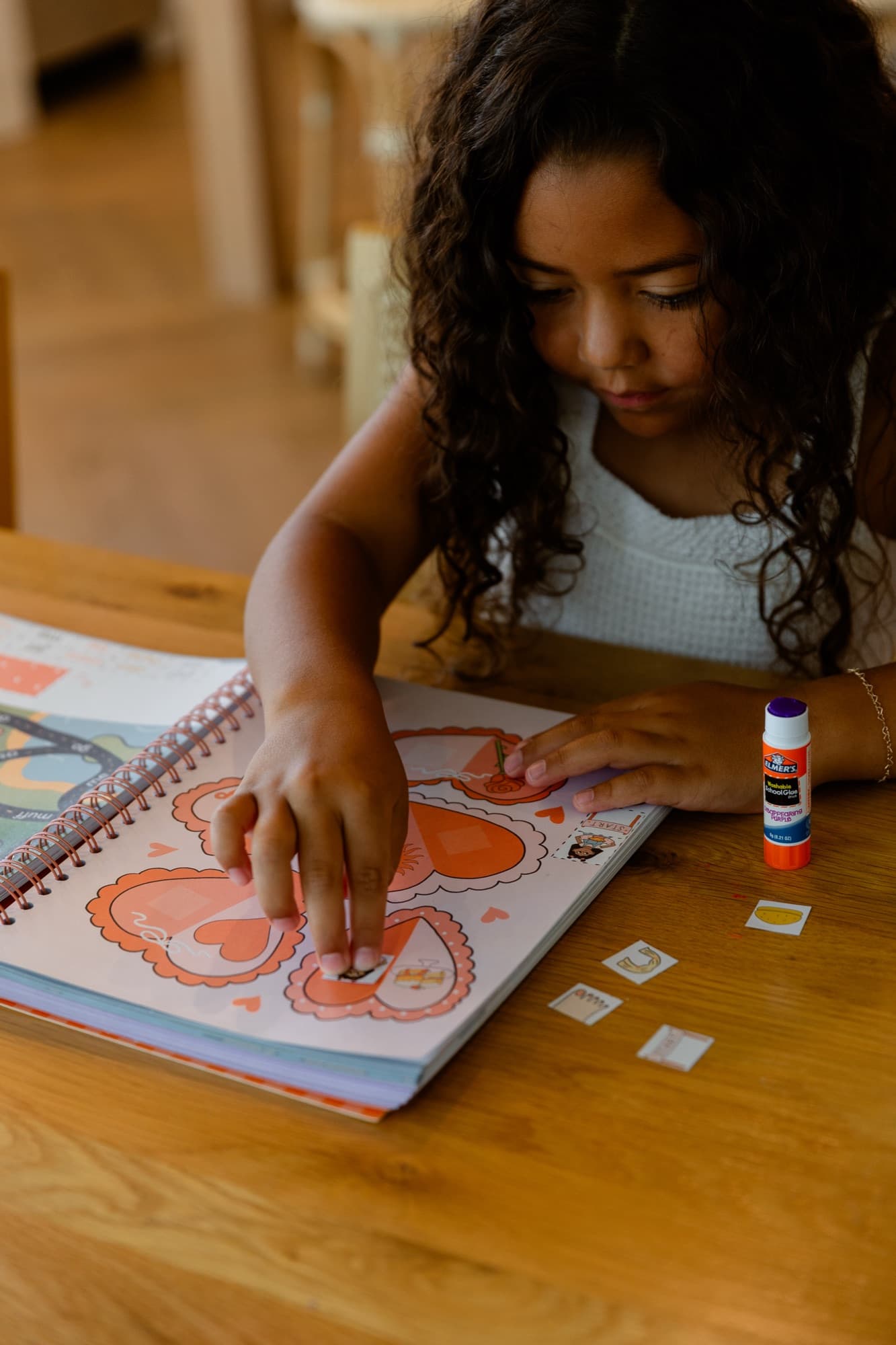 A child gluing activities into a lesson book